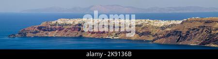 Telephoto and panorama of city of Oia on island of Santorini in Greece. Shot from very far away across the bay so the quality is not super good. Stock Photo