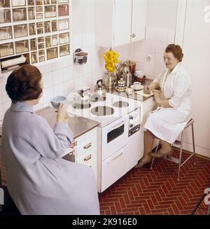 In the kitchen 1960s. Interior of a kitchen and a two women having tea and coffee. Sweden 1962 ref CV83 Stock Photo