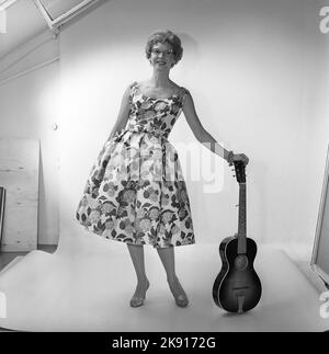 In the 1950s. A woman in the photographers studio wearing a dress patterned with flowers and leaves. Sweden 1959 Kristoffersson ref CF58-7 Stock Photo