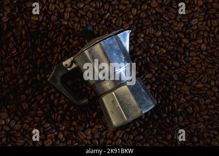 Metal coffee maker and a pattern of coffee beans in the shape of a circle  on a gray background with Stock Photo by Artjazz