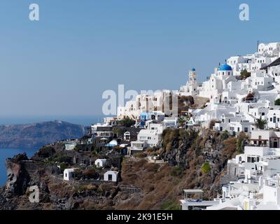 Town of Imerovigli set on a cliff with a traditional blue domed church on the Greek Cyclades island of Santorini in the Aegean Sea Stock Photo
