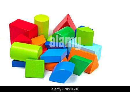 Wooden building blocks of different shapes and colors against a white background Stock Photo
