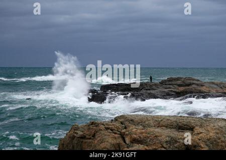 Waves crashing on the rocks along the shore Stock Photo