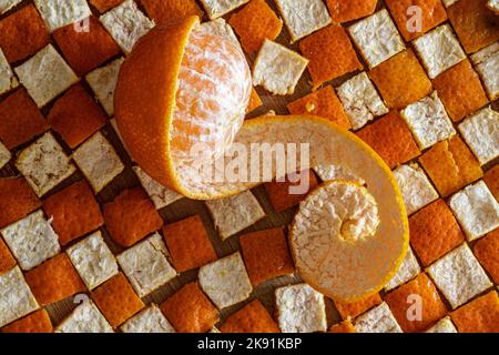 mandarin orange peeled in half on the peel in squares Stock Photo