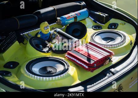 A close up of a tuned yellow Hyundai Coupe with stereo and toys in the trunk Stock Photo