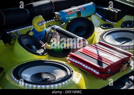 A close up of a tuned yellow Hyundai Coupe with stereo and toys in the trunk Stock Photo