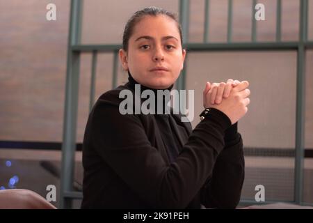 A beautiful businesswoman in a black classic jacket siting at the table in the office Stock Photo