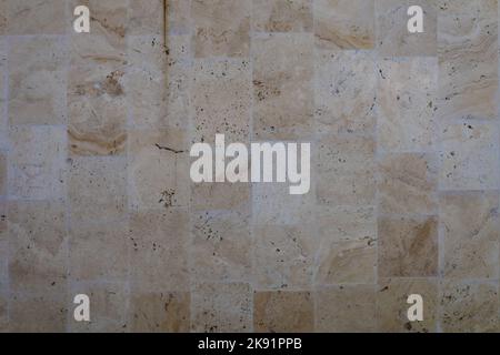 Smooth stone wall texture background. Texture of a brown sleek stone wall. Polished yellow stone wall as a background or texture. Background, texture. Stock Photo