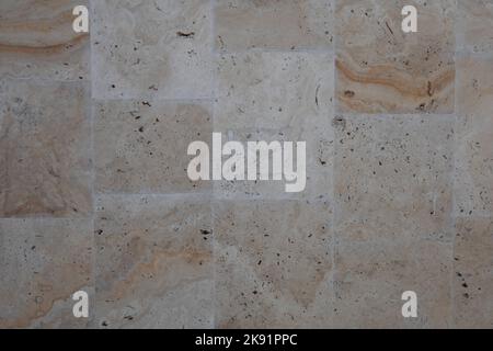 Smooth stone wall texture background. Texture of a brown sleek stone wall. Polished yellow stone wall as a background or texture. Background, texture. Stock Photo