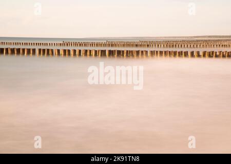 Rows of groynes in the calm Baltic Sea Stock Photo