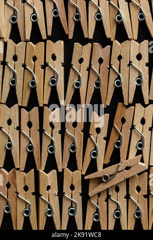 Row wood clothespins on black background Stock Photo