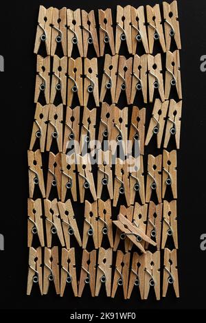 Row wood clothespins on black background Stock Photo
