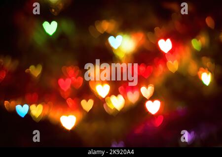 Multi-colored lights in shape of hearts. Blurred bokeh background for valentines day. Selective focus. Stock Photo