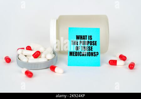 Medical concept. On a gray background, a jar, capsules and a sign with the inscription - What is the purpose of these medications Stock Photo