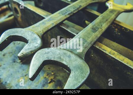 Closeup of Two Big and Dirty Open-End Wrenches Lying on Metal Surface. Hand-Held Workshop Tools and Equipment Theme. Stock Photo