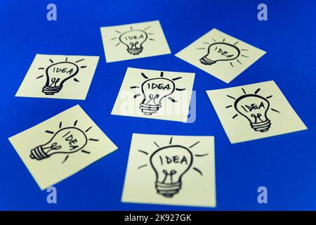 Light bulbs drawn on sticky notes. Hand drawn doodle lineart. Ideas, inspiration and creative thinking. Stock Photo