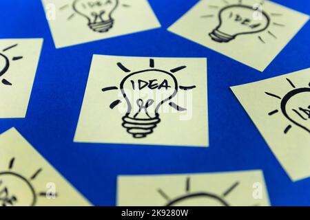 Light bulbs drawn on sticky notes. Hand drawn doodle lineart. Ideas, inspiration and creative thinking. Stock Photo