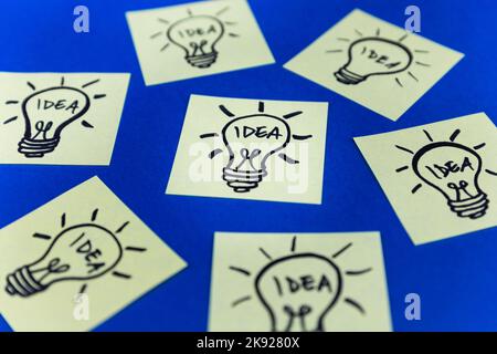 Light bulbs drawn on sticky notes. Hand drawn doodle lineart. Ideas, inspiration and creative thinking. Stock Photo