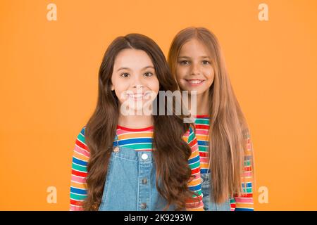 Best hairstyles for long hair. Cute small girls with long brunette and  blond curls in playroom. Adorable little children long loose hair. Enjoying  lon Stock Photo - Alamy