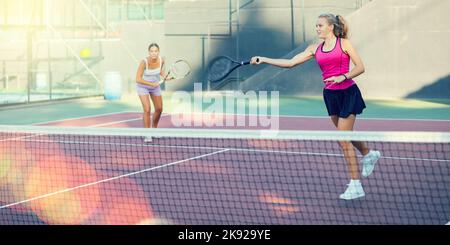 Young woman in skirt playing tennis on court Stock Photo