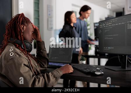 Pensive system engineer thinking at programming ideas trying to write html code and create new interface in data room. Web developer working at database in artificial intelligence developing agency. Stock Photo