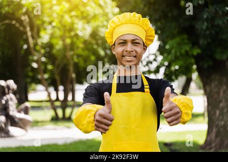 African children cooks in chefs hat and yellow uniforms grimacing and  showing tongue each others. African teenager and black girl have fun and  cook fo Stock Photo - Alamy