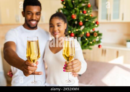 happy couple holding a glasses of champagne and celebrating new year at home Stock Photo