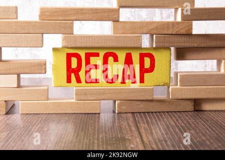 The text recap appearing behind torn yellow paper. Stock Photo