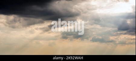 Dramatic Sky Background with sunny beams. Panoramic view of Stormy Clouds in Dark sky Stock Photo