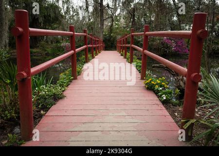 Red foot bridge spanning a swamp Stock Photo