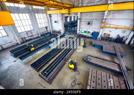 Long steel constructions assembling with welding in workshop Stock Photo