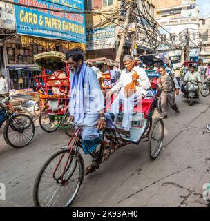 DELHI, INDIA - NOVEMBER 11, 2011: Cycle rickshaws with passenger in the streets in Delhi, India. Cycle rickshaws were introduced in the 1940's and hav Stock Photo