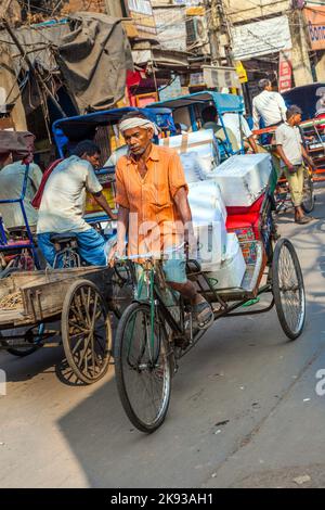 DELHI, INDIA - NOVEMBER 11, 2011: Cycle rickshaws with cargo load in the streets in Delhi, India. Cycle rickshaws were introduced in the 1940's and ha Stock Photo