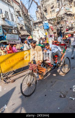 DELHI, INDIA - NOVEMBER 11, 2011: Cycle rickshaws with passenger in the streets in Delhi, India. Cycle rickshaws were introduced in the 1940's and hav Stock Photo