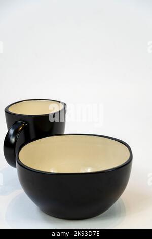 Different clean plates in dish drying rack on kitchen counter Stock Photo