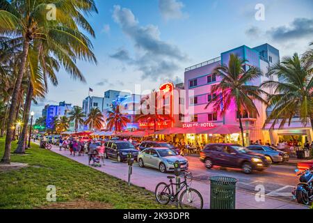 MIAMI, USA - AUG 23, 2014: people enjoy Palm trees and art deco hotels at Ocean Drive by night. The road is the main thoroughfare through South Beach Stock Photo