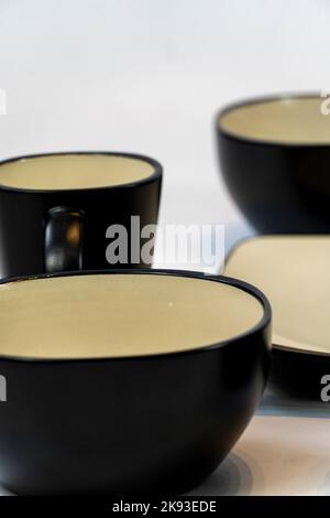 Different clean plates in dish drying rack on kitchen counter Stock Photo