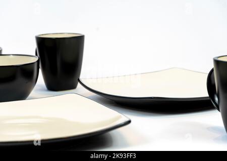 Different clean plates in dish drying rack on kitchen counter Stock Photo