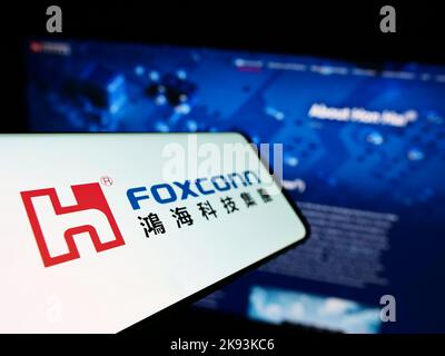 Smartphone with logo of Hon Hai Precision Industry Co. Ltd. (Foxconn) on screen in front of business website. Focus on left of phone display. Stock Photo