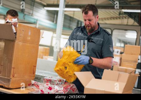 Cologne, Germany. 21st Oct, 2022. Jens Ahland, press officer of the customs, checks a plush figure. In search of drugs, customs checks several hundred packages every night. Credit: Marius Becker/dpa/Alamy Live News Stock Photo