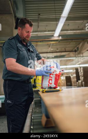 Cologne, Germany. 21st Oct, 2022. Jens Ahland, press officer at customs, checks a package. In search of drugs, customs checks several hundred packages every night. Credit: Marius Becker/dpa/Alamy Live News Stock Photo
