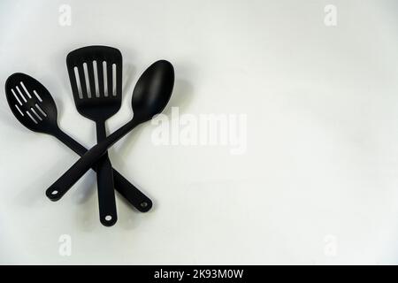 spatulas and spoons black plastic on white background, mexico Stock Photo