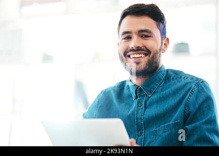 Modern tech is just what my tasks need. Cropped portrait of a handsome young businessman smiling while holding a digital tablet in an office. Stock Photo