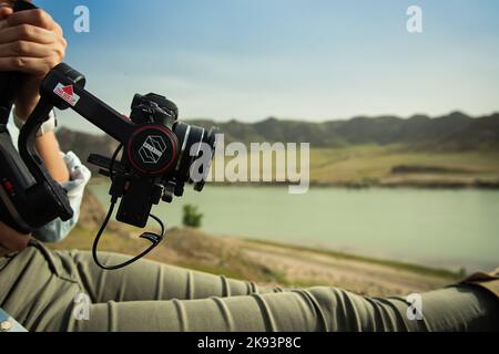 Compact Three-axis stabilizer Zhiyun Weebill S with dslr in operator hands outdoor Stock Photo