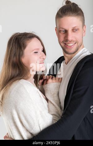 Young blond european couple of lovers close-up vertical portrait on white background Stock Photo