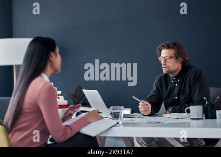 Were always productive when we work together. two young architects going over building plans and paperwork together in their office. Stock Photo