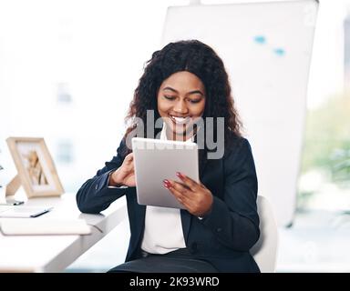 Her go to gadget for growing a business. a young businesswoman using a digital tablet in a modern office. Stock Photo
