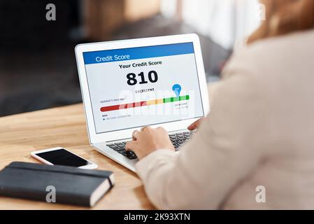 Maintaining a good credit score is very beneficial in business. an unrecognizable businesswoman using a laptop to check her credit score online in her Stock Photo