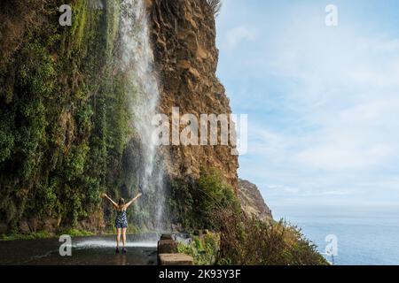 Cascata dos Anjos - woman standing under Angels waterfall in Madeira Stock Photo