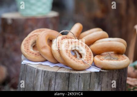 Bagels on a wooden stump. Bunch of freshly baked bread rolls. Stock Photo